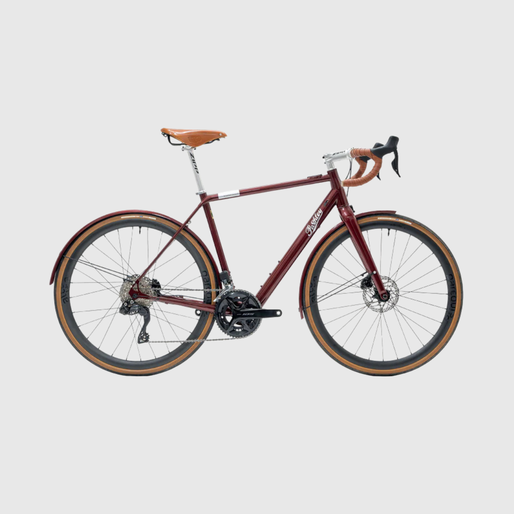 Red bicycle with brown seat and tires on a light gray background