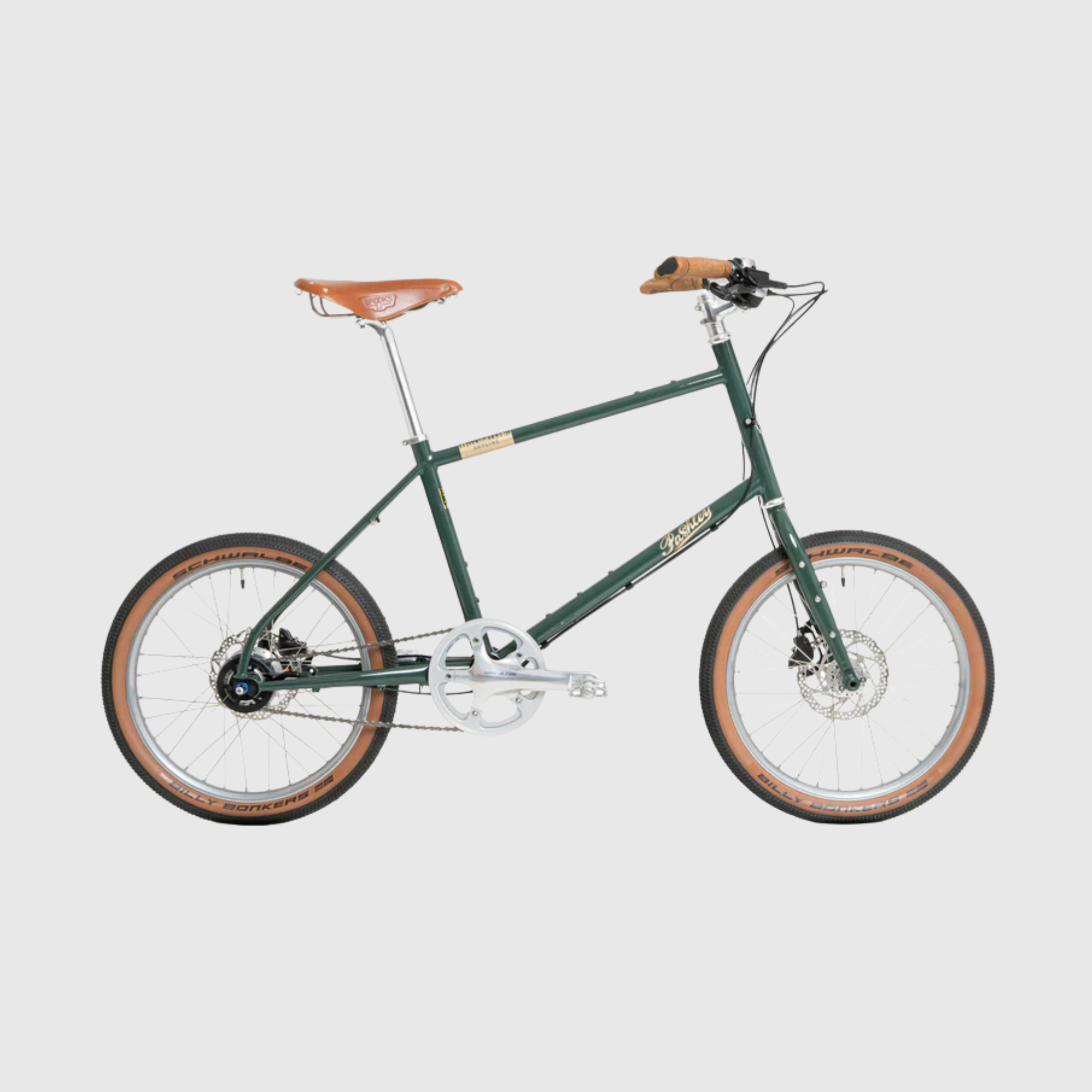 Green bicycle with brown seat and tires on a light gray background