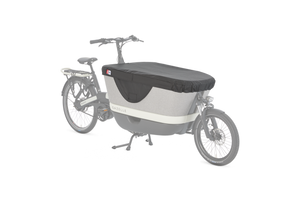 The Gazelle Makkig Load is shown at an angle with a cover over the high box at the front. The kickstand is in position demonstrating it's stability and you are able to see how the front fork is fastened to the front of the load box for maneuverability. 